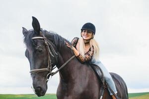 bellissimo ragazza equitazione un' cavallo nel campagna. foto