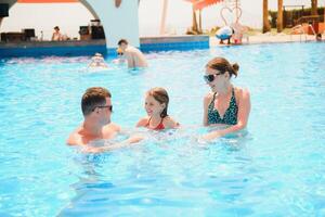 contento famiglia nel nuoto piscina a acqua parco foto