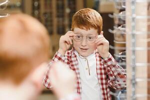 ragazzo nel bicchieri , a ottica negozio. foto