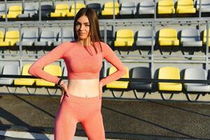 sport e ricreazione concetto. ragazza nel gli sport indossare in posa a stadio prima fitness esercizio. foto