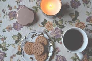 un' tazza di tè e candeliere su il bianca tavolo. foto
