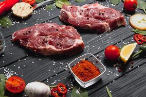 crudo Maiale carne su di legno taglio tavola a cucina tavolo per cucinando Maiale bistecca arrostito o grigliato con ingredienti erba e spezie , fresco Maiale. foto