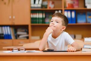 poco bambino scrittura con colorato matite, al chiuso. elementare scuola e formazione scolastica. ragazzo apprendimento scrittura lettere e numeri. foto