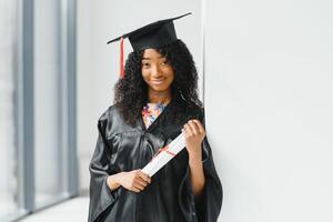 eccitato africano americano donna a sua la laurea. foto