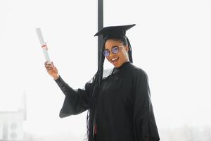 contento africano americano femmina alunno con diploma a la laurea foto