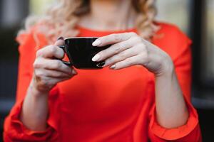 mani femminili che tengono una tazza di caffè foto