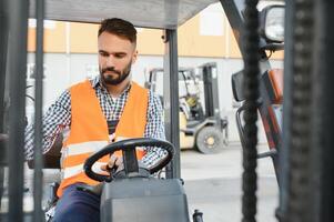 agitando carrello elevatore a forca autista nel il magazzino di un' trasporto azienda mentre guida carrello elevatore a forca foto