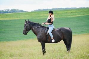 immagine di giovane bella ragazza equitazione cavallo foto