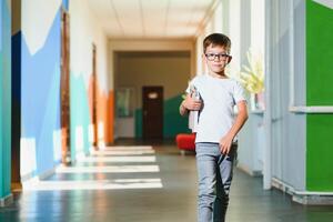 indietro per scuola concetto. scuola bambino nel classe. contento ragazzo contro verde lavagna. inteligente bambino nel aula. idea e formazione scolastica concetto foto