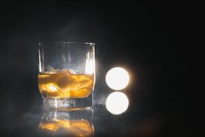 whisky con ghiaccio su nero sfondo con Fumo foto