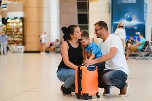 ritratto di in viaggio famiglia con valigie nel aeroporto foto