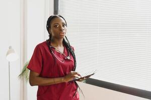 un africano americano femmina medico medico con un' stetoscopio nel Ospedale. foto