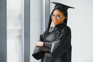 contento africano americano femmina alunno con diploma a la laurea foto