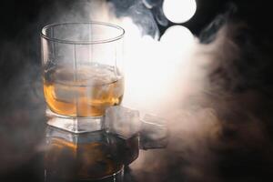 whisky con ghiaccio su nero sfondo con Fumo foto