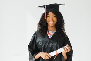 studente laureato afroamericano allegro con il diploma in sua mano foto