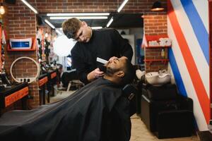 africano maschio cliente ottenere taglio di capelli a barbiere negozio a partire dal professionale parrucchiere. foto