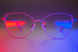 elegante occhiali da sole tiro utilizzando rosa e blu astratto colorato illuminazione con copia spazio. foto