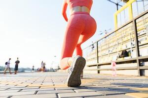 piedi del corridore in esecuzione su strada primo piano sulla scarpa. donna fitness alba jogging allenamento concetto di benessere. foto