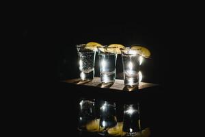 gustoso alcool bevanda cocktail Tequila con lime e sale su vivace buio sfondo. avvicinamento. foto