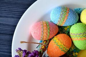 colorato Pasqua uova con fiori nel il piatto. bellissimo Pasqua sfondo. Pasqua carta. fatti in casa vacanza arredamento. foto