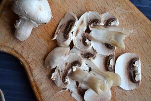 funghi su il buio blu di legno scrivania. cucinando champignon. foto