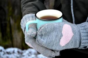 un' boccale di tè nel freddo tempo atmosferico. un' tazza di tè nel donna di mani. foto