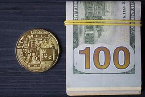 d'oro bitcoin e dollari nel maschio mano su un' buio blu di legno sfondo. oro moneta di criptovaluta. foto