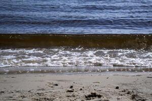 bagnato sabbia e morbido onde su un' spiaggia. foto