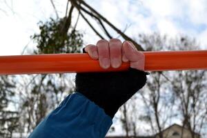 maschio mani su il orizzontale sbarra. uomo è impegnato nel gli sport. foto