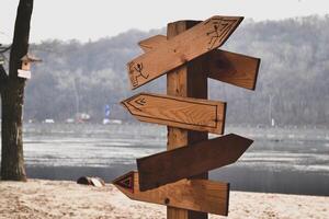 di legno pointer su il spiaggia. direzione frecce su il spiaggia. foto