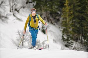 un' sportivo sciatore si arrampica con pelli di foca foto