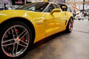 sinsheim, germania - 16 ottobre 2018 technik museum. altri veicoli a sfondo sfocato. lato sinistro della moderna auto gialla con luce al neon e ruota anteriore color argento foto