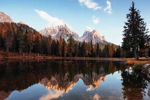 autunno profondo. splendide montagne tra le nuvole. grande paesaggio. boschi vicino al lago foto