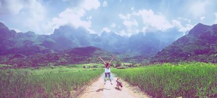 le donne asiatiche viaggiano rilassandosi durante le vacanze. saltando in mezzo alla strada del prato foto