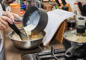 persona preparazione cremoso dolce con un' plastica cucchiaio nel il cucina foto