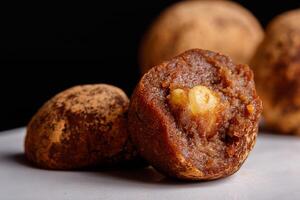 bellissimo caramella tartufo con un' Noce dentro su un' bianca piatto su un' nero sfondo foto