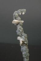 macro minerale pietra calcedonio con stelbite su un' grigio sfondo foto