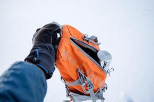 zaino con termos. un' piccolo turista zaino per arrampicata. il thermos è nel un Aperto Borsa. luminosa arancia Borsa per escursioni a piedi nel natura. foto