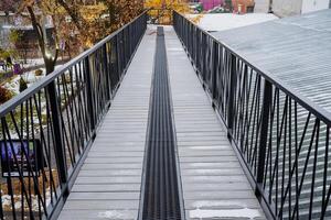 pedone ponte fra il edifici. metallo ponte nel il ricreazione parco. autunno città parco con paesaggio foto