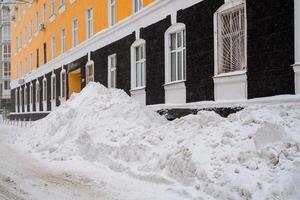 grande cumuli di neve nel il città. radura neve detriti. neve rimozione su città strade. servizi di pubblica utilità. pulito il neve. un' grande cumulo di neve è ammucchiati su. foto