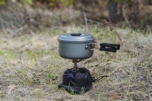 campo campo cucinando pentola, campeggio camper pasto, foresta il trekking campo il pranzo, compatto Ingranaggio, portatile gas bruciatore, campeggio utensili foto