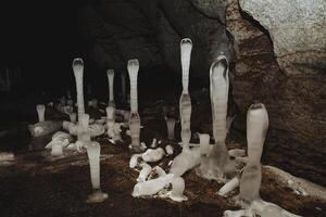 stalagmite ghiaccio nel il grotta cresce su il pavimento, bellezza sotto il terra, carsico cavità, speleologia, dolina nel il terra. foto