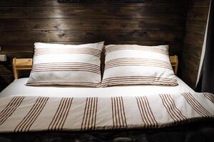accoppiato cuscini fatto di morbido tessuto con un' geometrico modello. accogliente di legno stanza, profonda dormire. il offuscare leggero nel il legna camera. cotone letto biancheria. foto