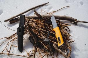 il coltello bugie su il Di legno, il turisti attrezzatura per fabbricazione un' fuoco. sopravvivenza nel il selvaggio nel inverno. foto