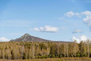 il antico vulcano è un' a forma di cono montagna, un' montagna paesaggio, il natura di Russia bashkortostan, montare arviakryaz meridionale Urali, foresta, blu cielo, primavera tempo atmosferico. foto