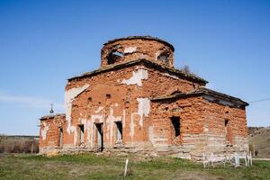 il rovine di un vecchio ortodosso Chiesa, un antico Chiesa contro il blu cielo, il resti di il muri di un' cristiano monastero, un antico costruzione, un' rotto tetto, un' religioso costruzione. foto