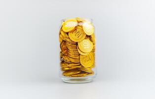 Salvataggio oro monete nel un' bicchiere barattolo, risparmi concetto, finanziario pianificazione e investimento denaro contante flusso e reddito foto