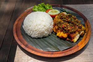 fracassato fritte pollo con verde chili salsa o ayam geprek samba hijau servito con vapore riso su di legno piatto foto