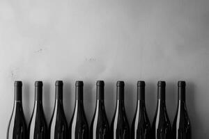 ai generato bottiglie di vino nel un' riga contro il sfondo di un' calcestruzzo grigio parete. vino sfondo con copia spazio foto