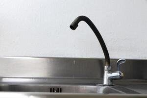 vecchio rubinetto arrugginito su il lavello. foto